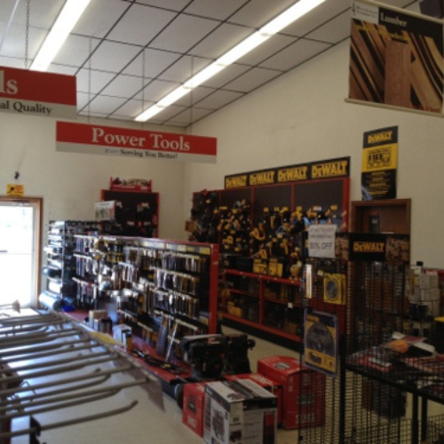 A well-lit hardware store aisle with shelves full of power tools and accessories under 