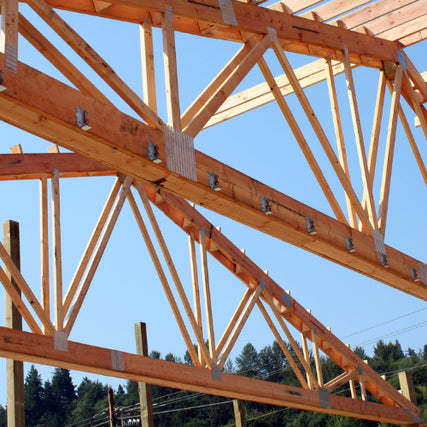  TrussesClose-up of wooden roof trusses under clear blue sky. The angled beams create geometric patterns, suggesting construction in progress.